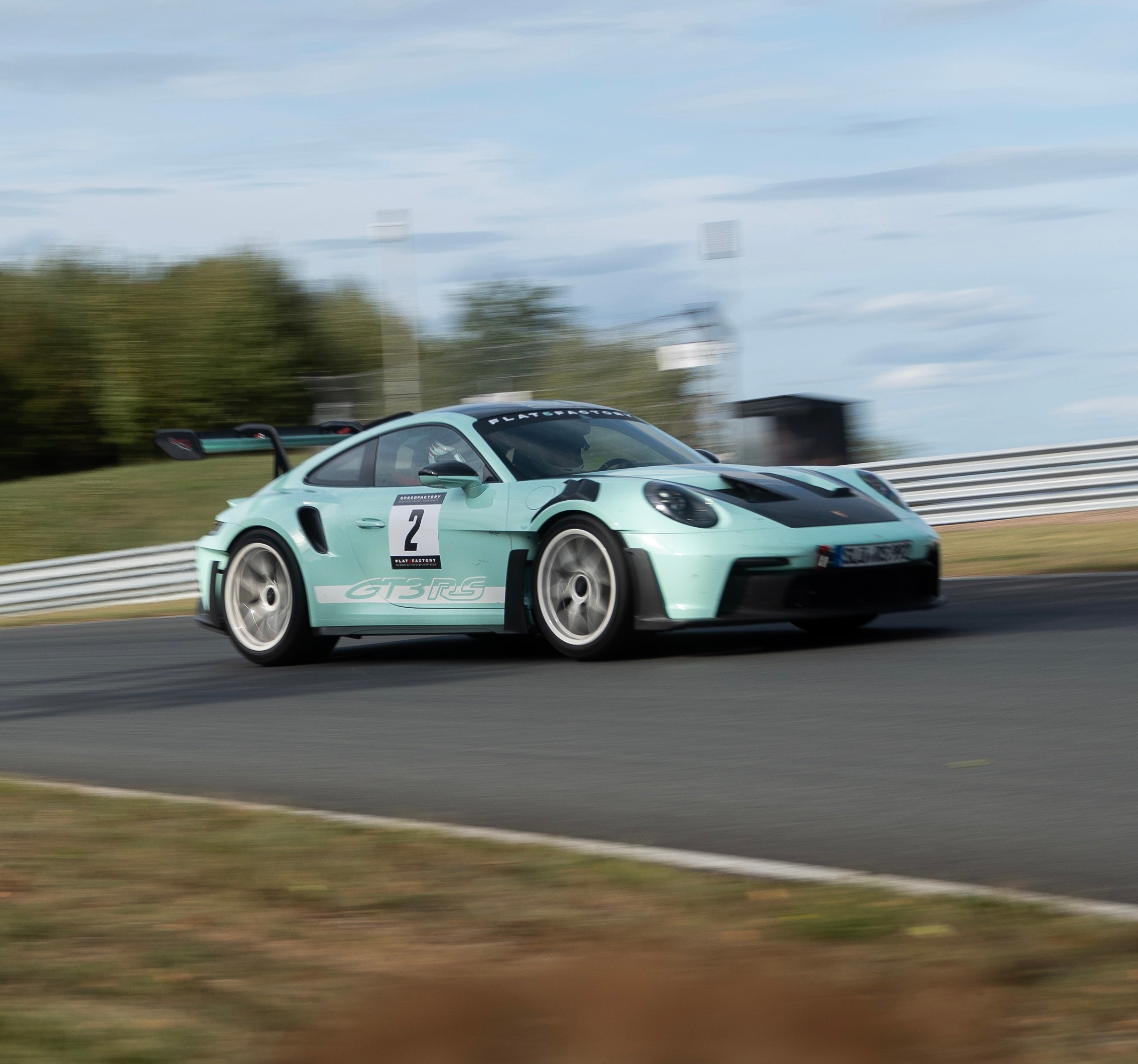 Türkiser Porsche GT3 RS von Flat6Factory auf der Rennstrecke